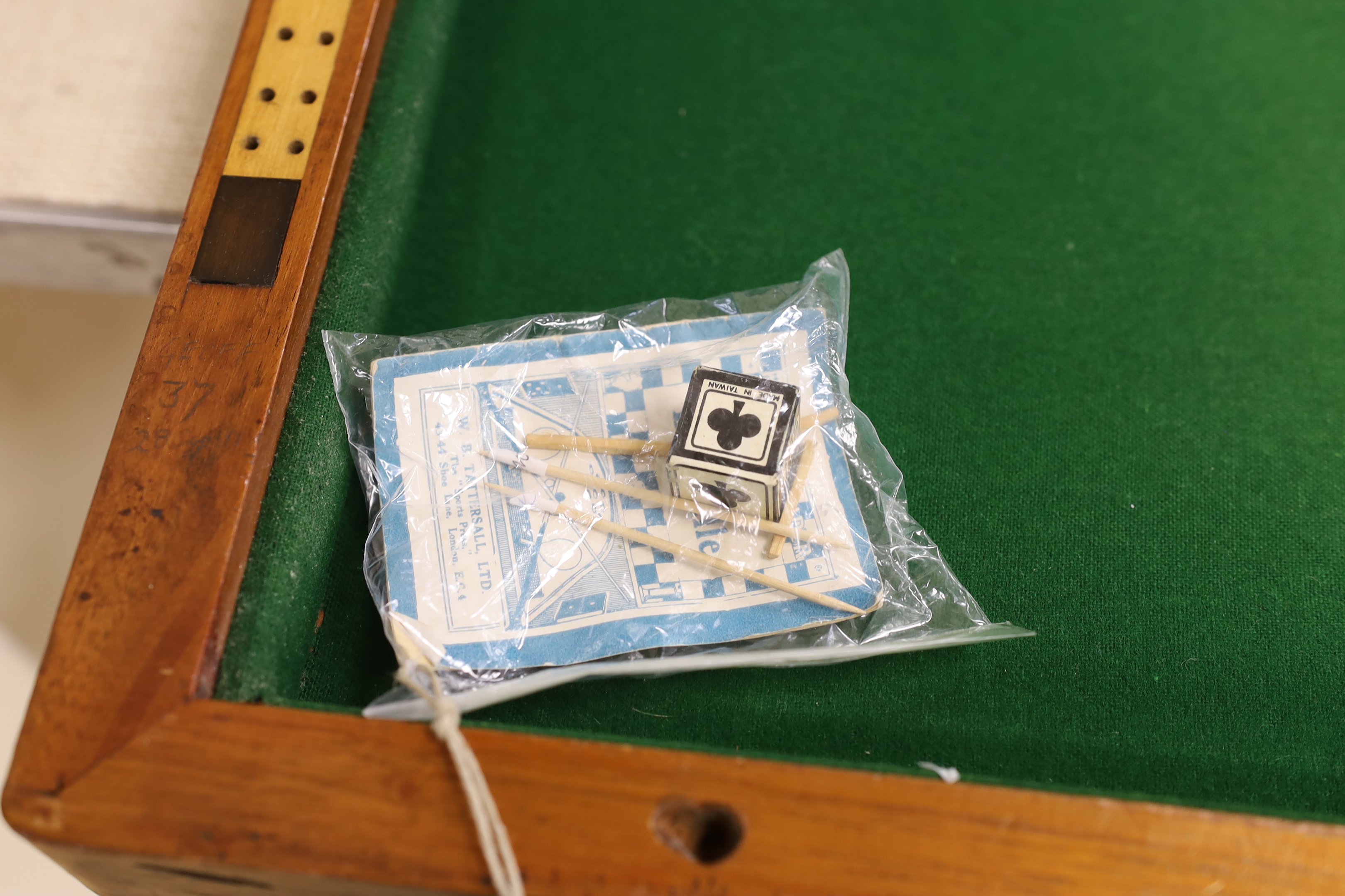 A Victorian folding cased bagatelle board, green baize interior with markers and two cues, 223.5cm open